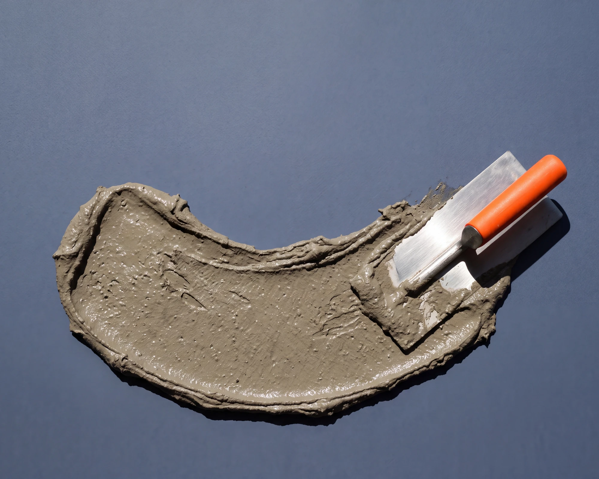 Concrete finishing trowel and mortar sweep on slate paper